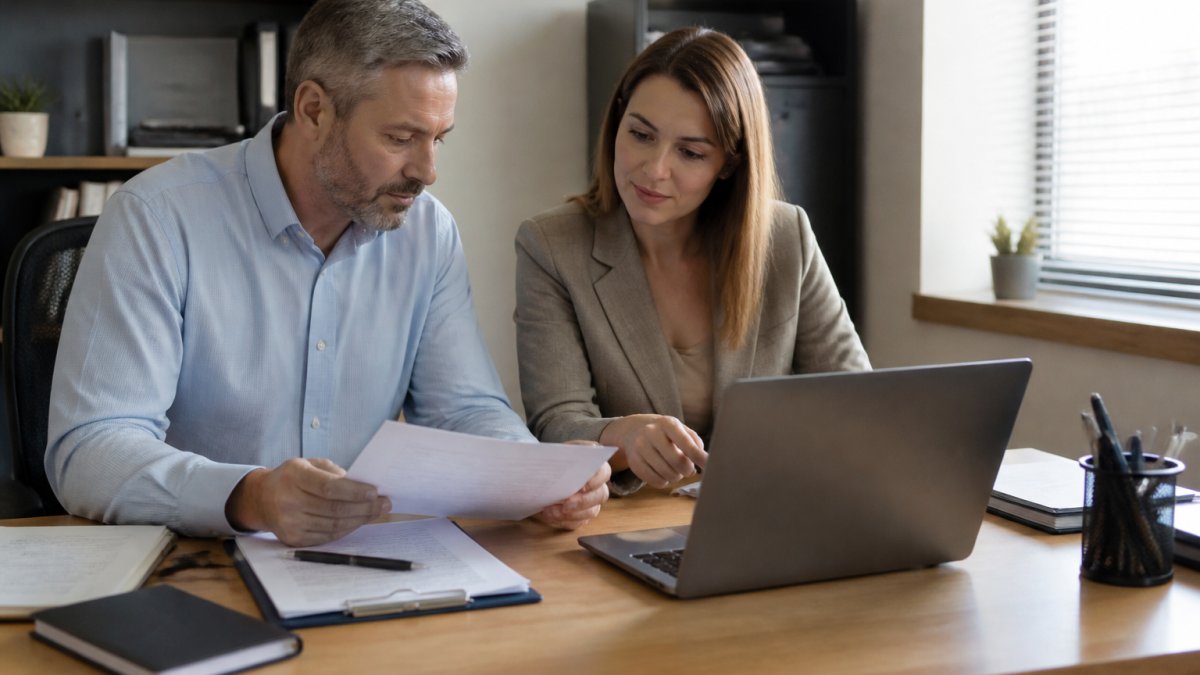 HR manager and business owner reviewing a screening dashboard on a laptop as a checkr alternative for hiring